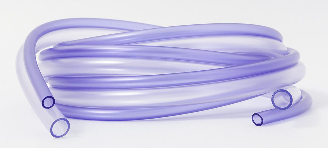 A coil of purple-colored medical tubing against a white background.