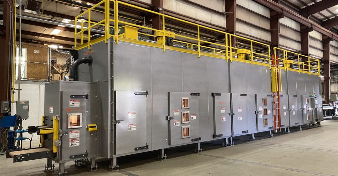 A custom triple conveyor oven inside a factory.